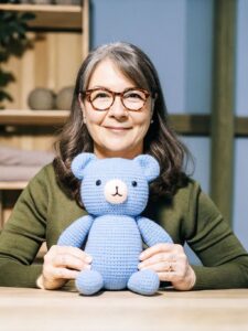 Martha crocheting amigurumi at her yarn table