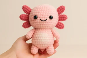 Free Axolotl Crochet Pattern PDF plush toy sitting on a gift box