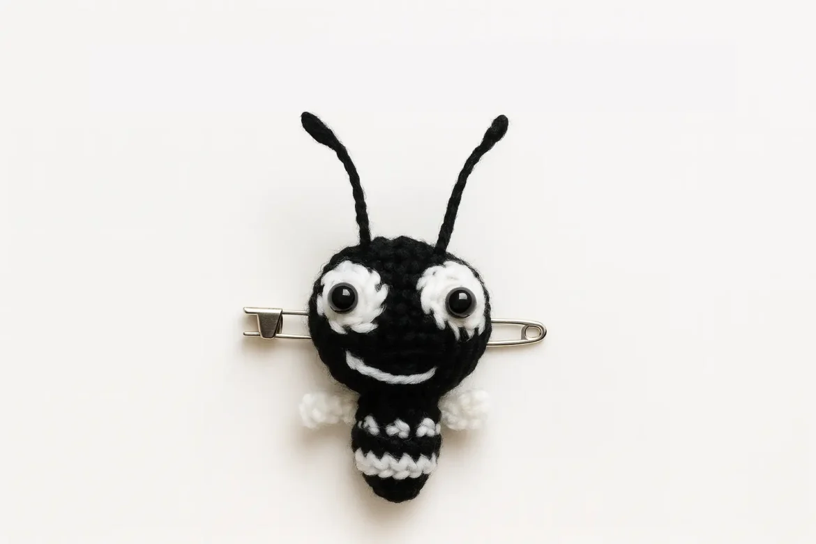 Crochet Ant Easy Amigurumi Keychain brooch version with asymmetric eyes and tiny wings on a safety pin