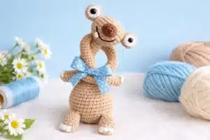 Sid the sloth amigurumi pattern finished long-neck sloth crochet doll with yarn balls and flowers