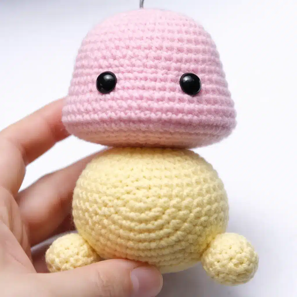 Head step for pastel caterpillar crochet pattern showing pink crochet head and first yellow body segment