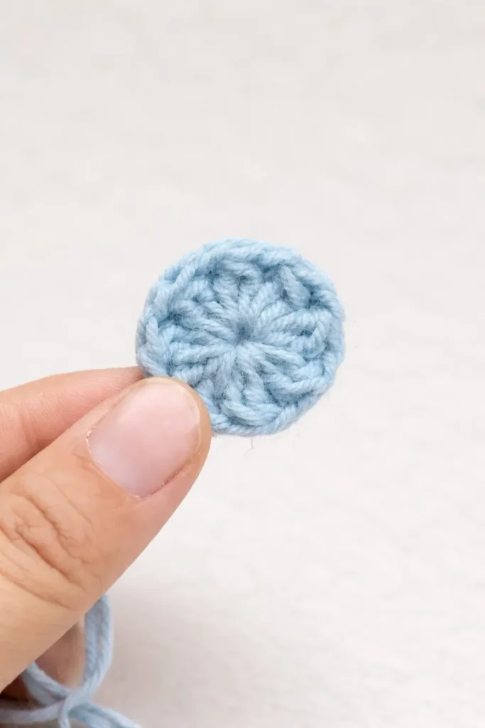 Pastel floral granny square crochet pattern blue center round held by hand