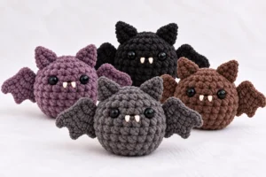 No-sew mini bat crochet pattern in gray, black, purple, and brown